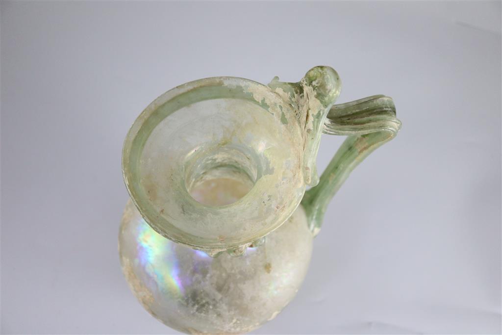 A good Roman olive green glass ewer or pitcher, Eastern Mediterranean, 3rd/4th century AD, 32cm high